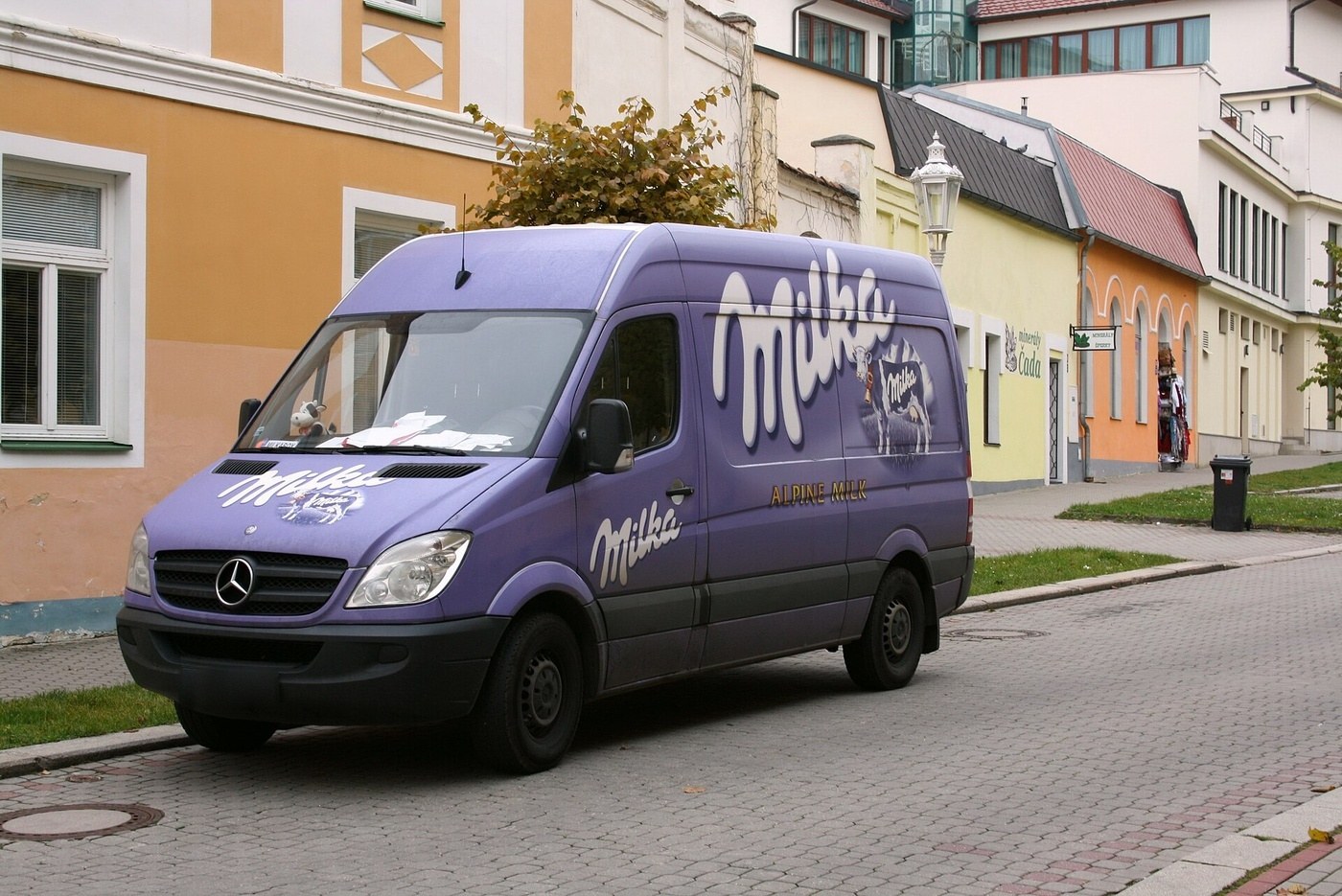 Weißer Transporter mit Firmenbeschriftung und Streifen